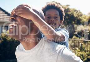 Portrait of a happy african american man bonding with his young little boy outside. Two black male father and son looking happy and positive while being affectionate and playing in a backyard