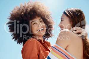 Portrait of two young mixed race female friends embrace and smiling outside on a sunny day. A Beautiful gay hispanic woman with a cool afro hair style being affectionate with her asian partner