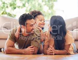 So much love in one picture. Full length shot of an affectionate young family of three lying on the living room floor at home.