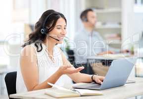 Ill sort it out for you, dont worry. a young call centre agent working on a laptop in an office.