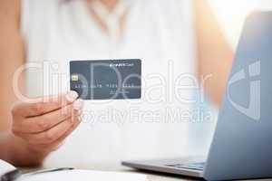 Purchasing some essentials for business. Closeup shot of an unrecognisable businesswoman using a laptop and credit card in an office.