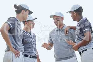 Baseball coach from below giving match pep talk and planning game strategy with group of players in huddle on sports pitch outside. Trainer encouraging and motivating team for tournament competition