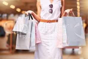 Cropped close up view of female hands carrying bags during a shopping spree. Stylish woman shopping in a mall while holding purchased items. Look at what I got on sale