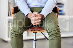 Businessman with his hands clasped showing power and confidence. Unknown mixed race professional sitting alone in an office and patiently waiting. Anticipating corporate entrepreneur feeling ready