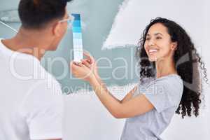 We freshening up this room. Shot of a young couple looking at a color swatch while busy renovating a house.