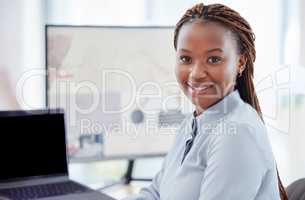Portrait of african american businesswoman sitting alone in her office and using a computer. Smiling black professional feeling confident while using a laptop. Leading black entrepreneurs in business