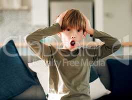 My minds blown right now. Portrait of a cute little boy reacting to something surprising while sitting on a sofa at home.