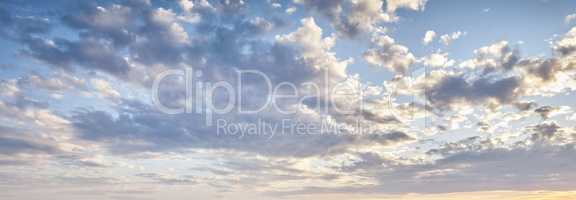 Cumulus clouds in a blue sky from below. Beautiful panoramic of fluffy, puffy and soft white cloudscape background symbolizing spirituality and heaven. Climate and weather in the atmosphere outside