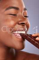 Ive been craving this. Studio shot of a beautiful young woman biting a piece of chocolate.