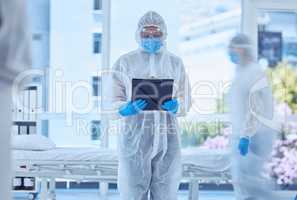 Biologist reading a medical report in hospital. Biochemist reading paperwork on clipboard in quarantine hospital room. Medical specialist in antiseptic hazmat suit. Scientist holding pandemic report