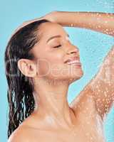 This is my favourite time of day. Shot of a young woman taking a shower against a blue background.