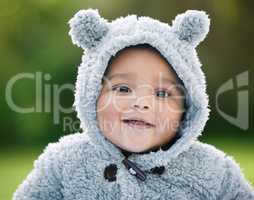 Dont you just wanna cuddle this cutie. Portrait of an adorable baby boy wearing a furry jacket with bear ears outdoors.