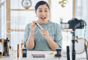 One beautiful young mixed race woman feeling excited and talking at home while camera vlogging a new makeup product. Amazed hispanic beauty expert reviewing cosmetics for skincare routine tutorial