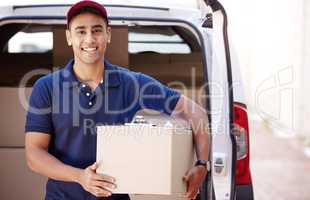 We pride ourselves on our quick and efficient service. Portrait of a young delivery man loading boxes from a van.