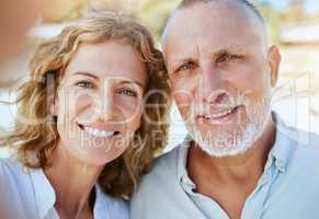 Portrait of happy mature caucasian couple taking a selfie while bonding together on holiday outdoors. Loving husband and wife capturing photos for memories while enjoying retirement and vacation