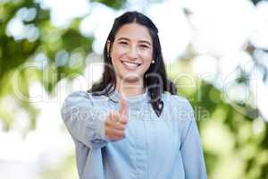 I wish you many successful opportunities. Portrait of a young businesswoman showing thumbs up in the city.