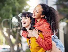 Make a smile your signature accessory. Shot of two young women enjoying a piggyback ride outdoors.