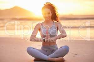 Only good can come from a meditation session. a young woman practicing yoga on the beach.