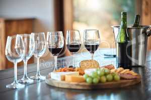 A row of glasses and a cheese board set up for a wine tasting inside a restaurant. A cheese platter the right wine is the perfect pairing for a relaxing and carefree day out, to get away from it all