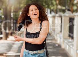 Beautiful young mixed race woman with an afro removing her mask and looking happy. The end of the corona virus pandemic. female looking free and relieved while breathing fresh air outside in the city