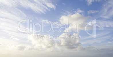 Cloudy blue sky with fluffy clouds as a natural background on a summer day. Landscape view of cumulus forming with copy space. High scenic and copyspace views of the atmosphere and the climate