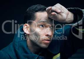 Its a risky business. Studio shot of a handsome young male firefighter looking thoughtful against a black background.