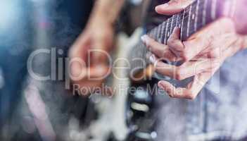 This one goes out to you. Closeup shot of an unrecognizable male guitarist performing on stage.