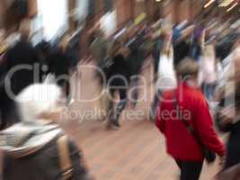 A group of people commuting through urban roads with blurred motion. A busy crowd of travelers arriving and walking together in a street in the city. Lots of tourists in defocused movement downtown
