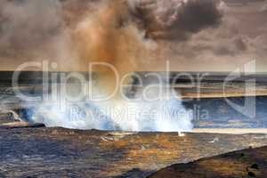 Mouna Kea most active volcano on a cloudy day. Extreme panoramic landscape of Hawaiian mountains and rocky surface. Overcast skies with a steaming volcanic area. Smoke coming out of crater