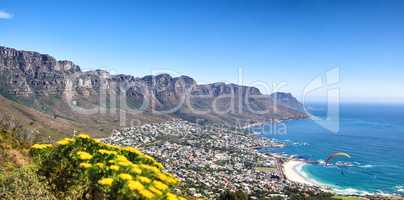 Landscape of a mountain range near a coastal city against a blue horizon in summer, South African. Wide angle wallpaper of The twelve apostles near calm sea and popular travel location for copy space
