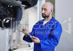 Safety is his number one concern. a handsome young male mechanic working on the engine of a car during a service.