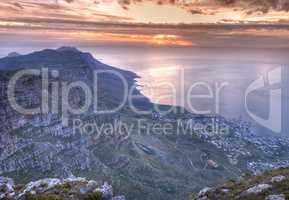 Beautiful view of an iconic landmark and famous travel or vacation destination to explore nature in South Africa. Aerial view of the sea and Table Mountain on a cloudy day at sunset with copy space.