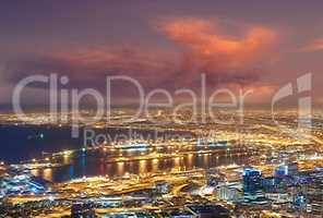 Scenic view of Cape Town at night from Signal Hill in South Africa. Beautiful landscape view of the city lights and buildings against a dark and cloudy evening sky. Popular tourist town at twilight