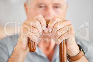 This really helps me get around. Closeup shot of a senior man holding a walking stick.