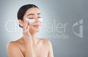 Doing away with wrinkles. an attractive young woman posing in studio against a grey background.