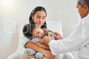 It only hurt a bit. a mature male doctor applying a bandaid to a little boys arm at a hospital.