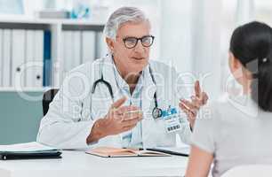 This is a common reaction. a mature doctor sitting with his patient during a consultation in his clinic.