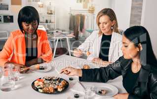 Food brings people together. a group of female friends enjoying sushi together.