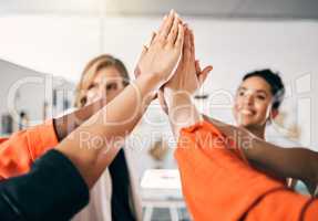 The higher we aim, the greater the success. a group of businesswoman giving each other a high five in an office at work.