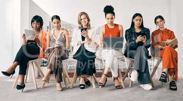 Women ruling the business world. a group of businesswomen sitting in a row in an office at work.