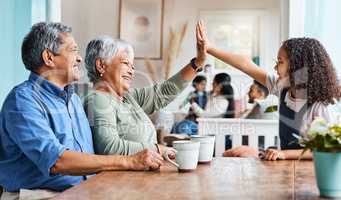 Theyre always cheering her on. Shot of a grandchild giving her grandmother a high five at home.