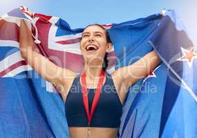 Young fit female athlete cheering and holding a New Zealand flag with a gold medal after competing in the Olympics. Smiling active sporty woman feeling motivated and celebrating winning in sport