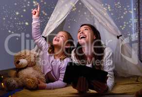 Who said that magic doesnt exist. a little girl and her mother using a digital tablet before bedtime.