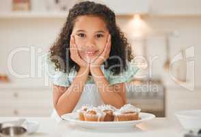 How long until I can eat these. a little girl patiently waiting to eat the freshly baked cupcakes.