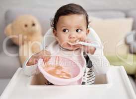 Baby girls are precious gifts. a baby eating a meal at home.