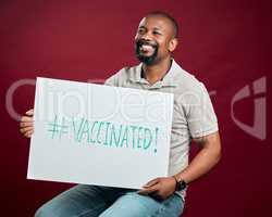 African american covid vaccinated man showing and holding poster. Smiling black man isolated against red studio background with copyspace. Happy model using sign to promote corona vaccine and motivate