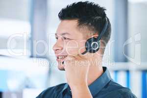 One happy hispanic call centre telemarketing agent talking on a headset while working in an office. Confident friendly male consultant operating a helpdesk for customer service and sales support