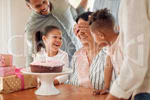A mother deserves the world for the sacrifices she makes. a family surprising their mother with a birthday cake at home.