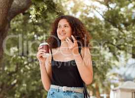 One young mixed race woman enjoying the city and using her cellphone to connect while drinking a takeaway coffee. Hispanic woman on a call while traveling in a new place