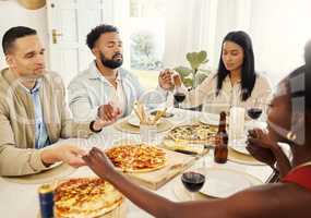 The bond we share is a special one. Shot of a group of friends saying grace before eating a meal together.